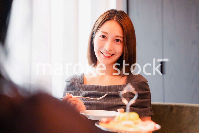 ホテルでアフタヌーンティーを楽しむ若い二人の女性