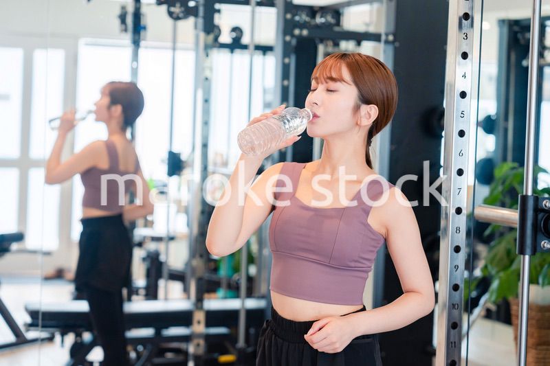 ジムで水分補給をする若い女性