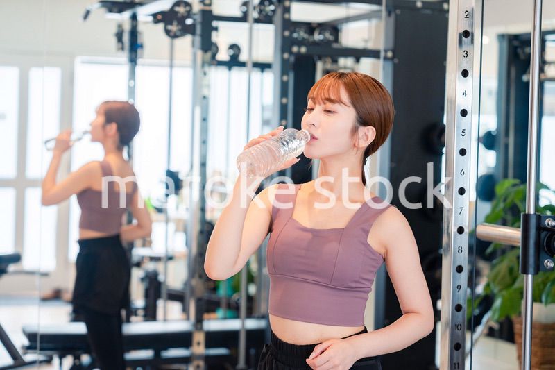 ジムで水分補給をする若い女性