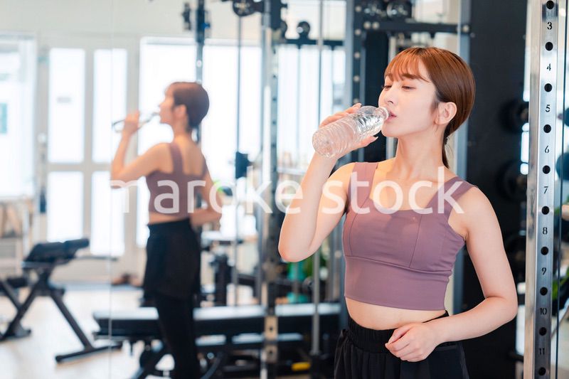 ジムで水分補給をする若い女性