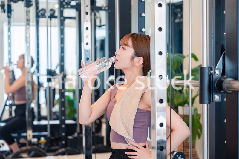 ジムで水分補給をする若い女性