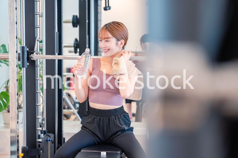 ジムで水分補給をする若い女性