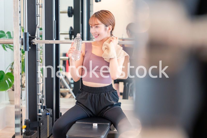 ジムで水分補給をする若い女性
