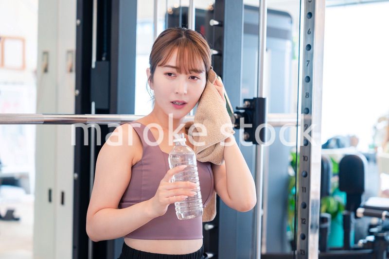 ジムで水分補給をする若い女性