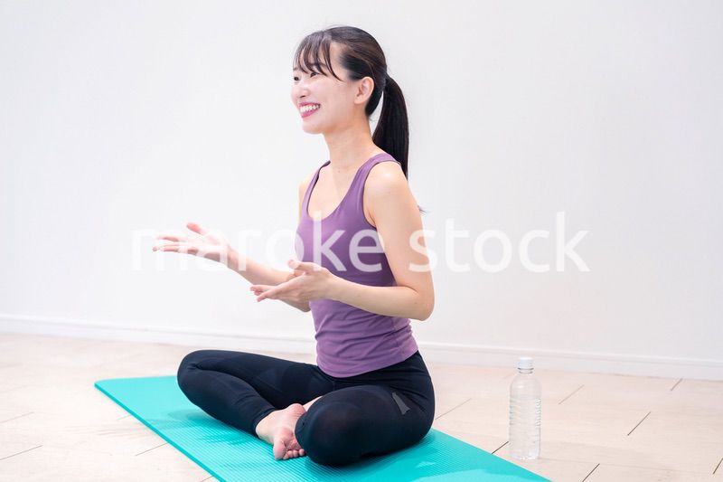 ジムでヨガコーチをするスポーティーな女性