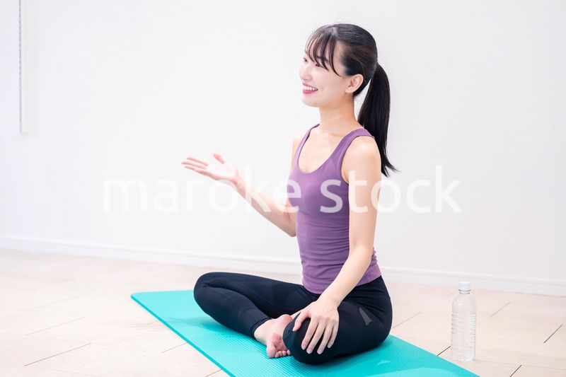 ジムでヨガコーチをするスポーティーな女性