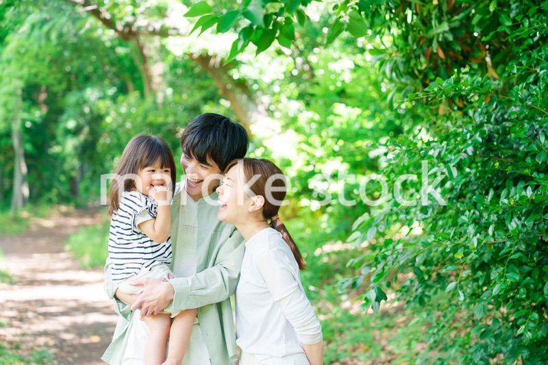 自然の中を歩いてアウトドアを楽しむ若いファミリー