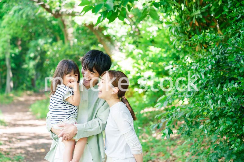 自然の中を歩いてアウトドアを楽しむ若いファミリー