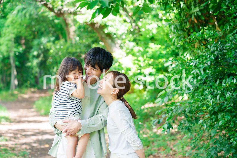 自然の中を歩いてアウトドアを楽しむ若いファミリー