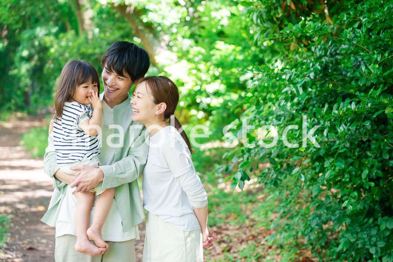 自然の中を歩いてアウトドアを楽しむ若いファミリー