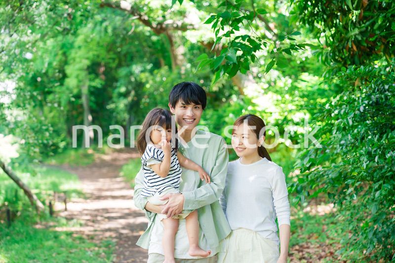 自然の中を歩いてアウトドアを楽しむ若いファミリー