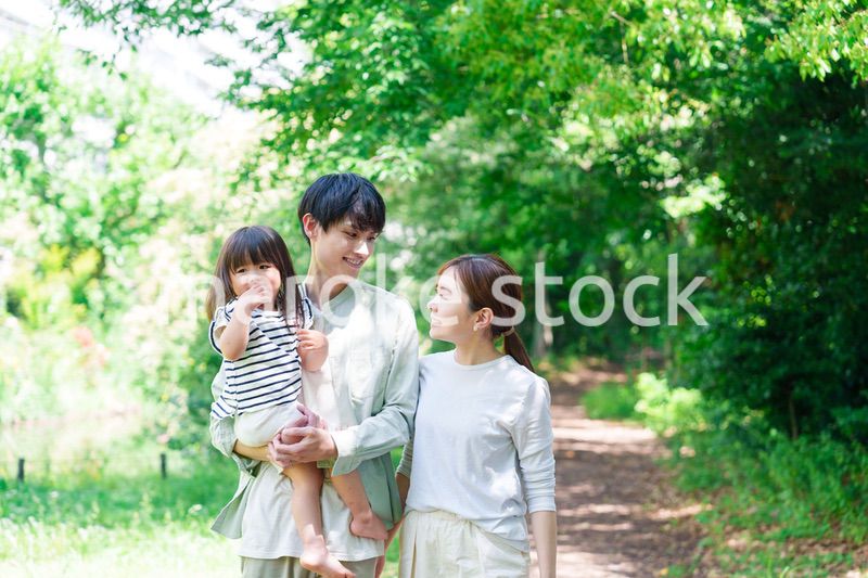 自然の中を歩いてアウトドアを楽しむ若いファミリー