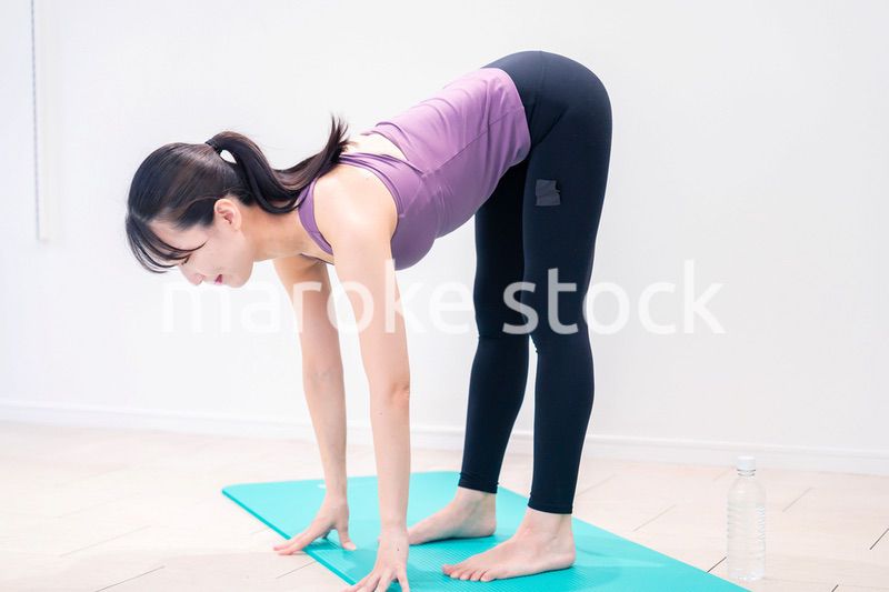 ジムでヨガコーチをするスポーティーな女性