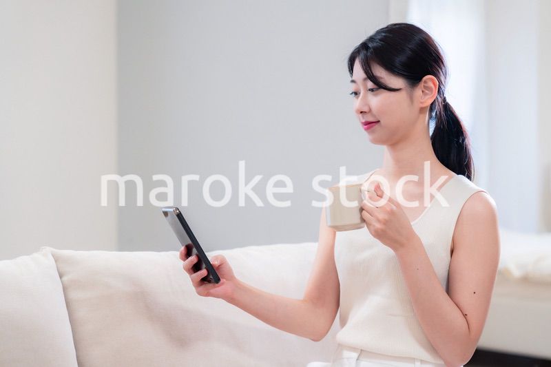 家でソファに座ってリラックスをする若い女性