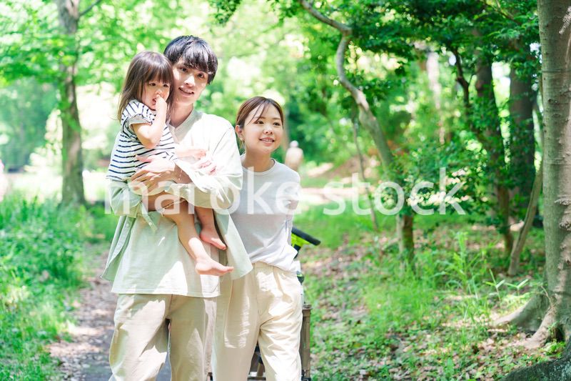 自然の中を歩いてアウトドアを楽しむ若いファミリー