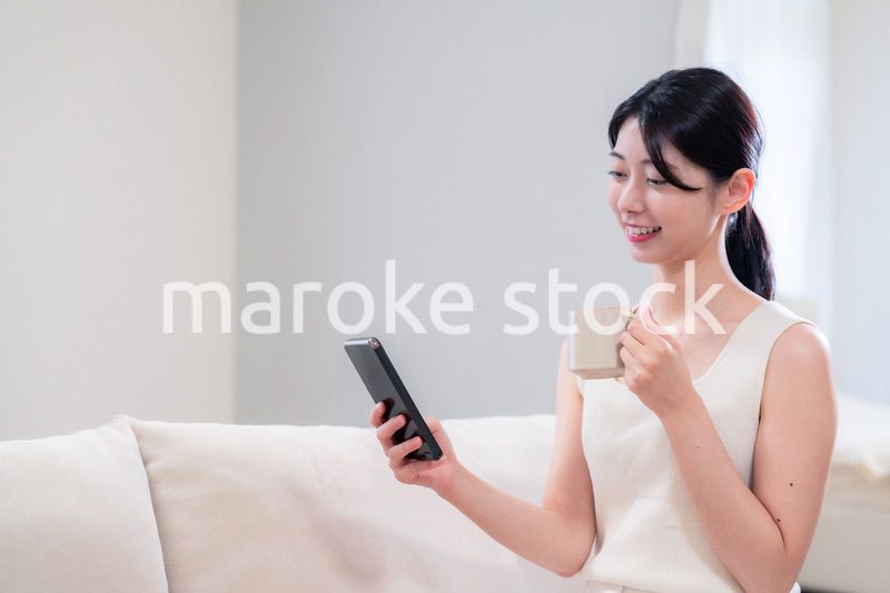 家でソファに座ってリラックスをする若い女性