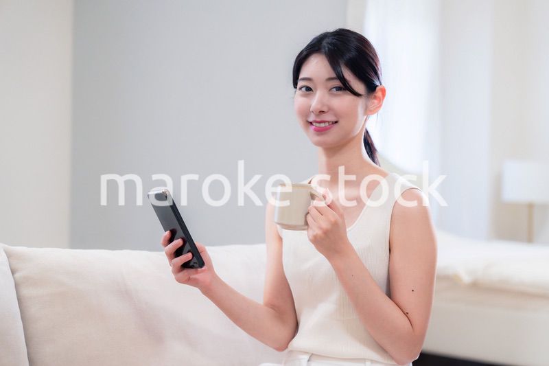 家でソファに座ってリラックスをする若い女性