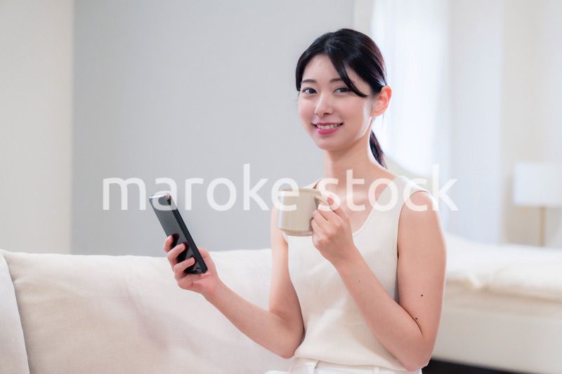 家でソファに座ってリラックスをする若い女性