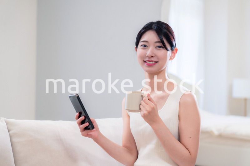 家でソファに座ってリラックスをする若い女性