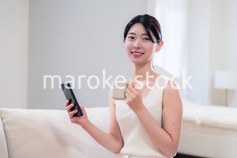 家でソファに座ってリラックスをする若い女性