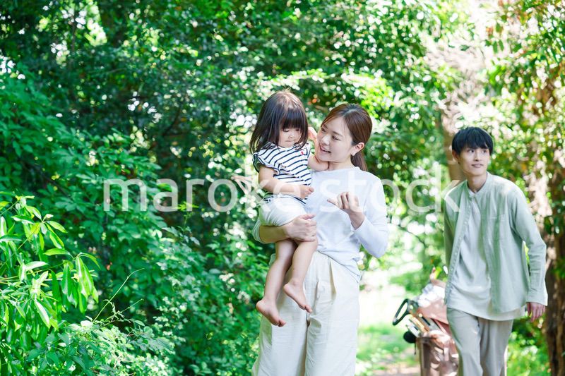 自然の中を歩いてアウトドアを楽しむ若いファミリー