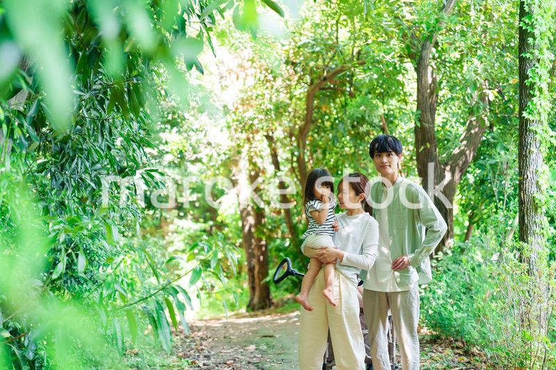 自然の中を歩いてアウトドアを楽しむ若いファミリー