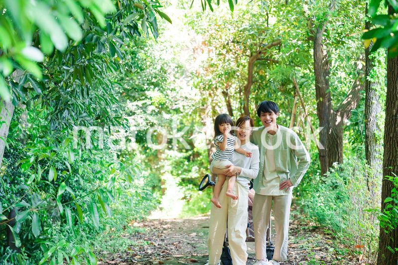 自然の中を歩いてアウトドアを楽しむ若いファミリー