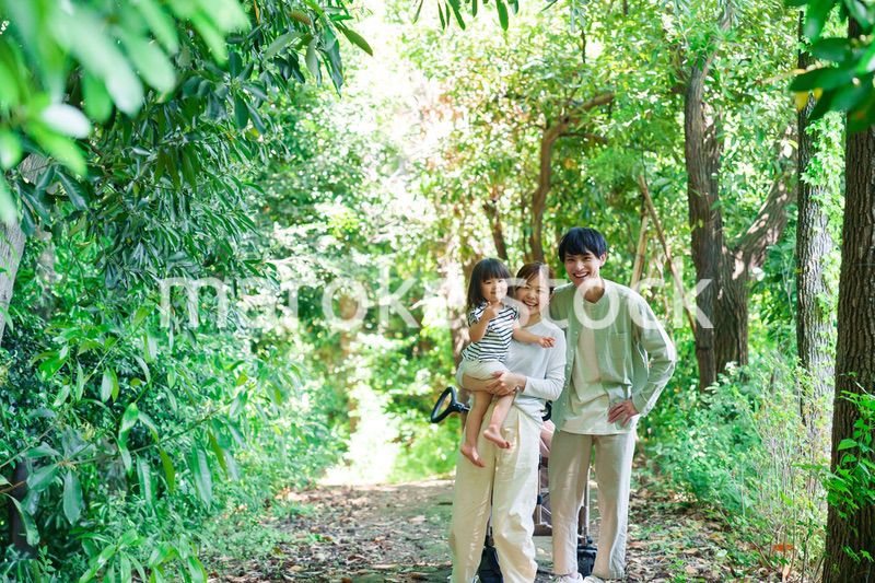 自然の中を歩いてアウトドアを楽しむ若いファミリー