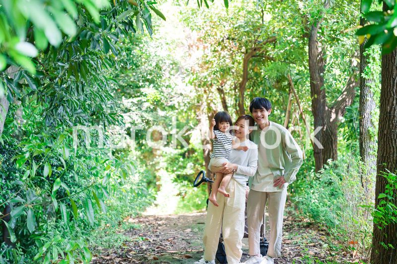 自然の中を歩いてアウトドアを楽しむ若いファミリー