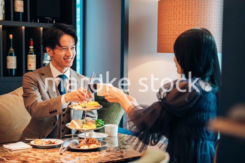 若い女性とアフタヌーンティーを楽しむ男性
