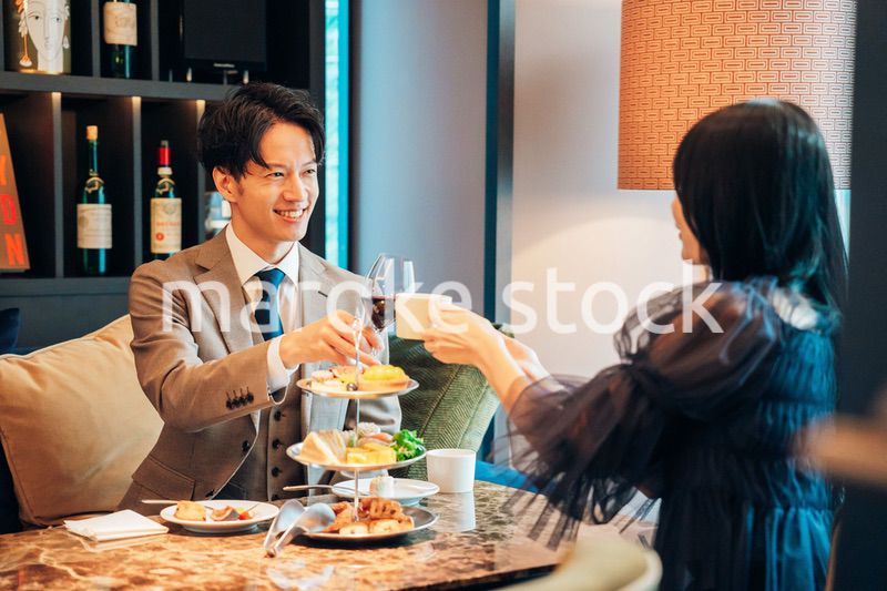 若い女性とアフタヌーンティーを楽しむ男性