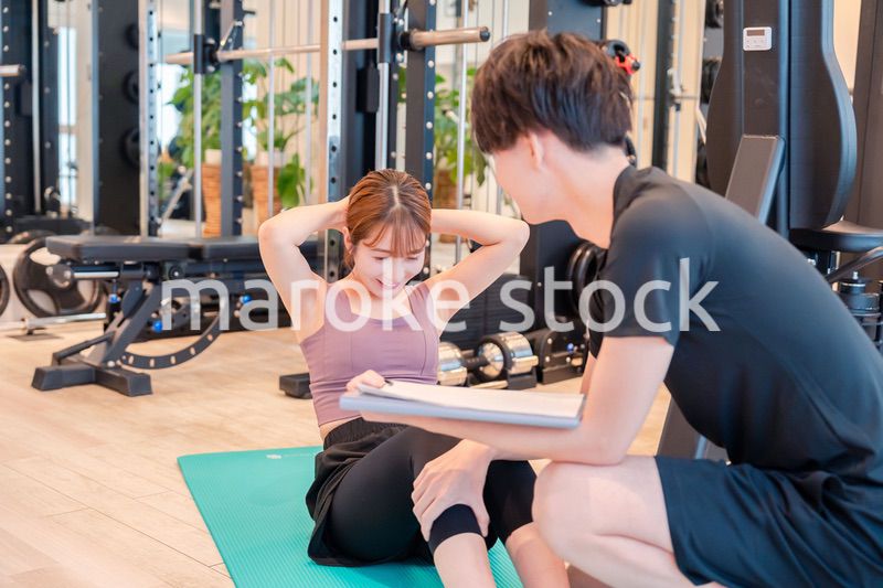 パーソナルジムに通う女性とトレーナー