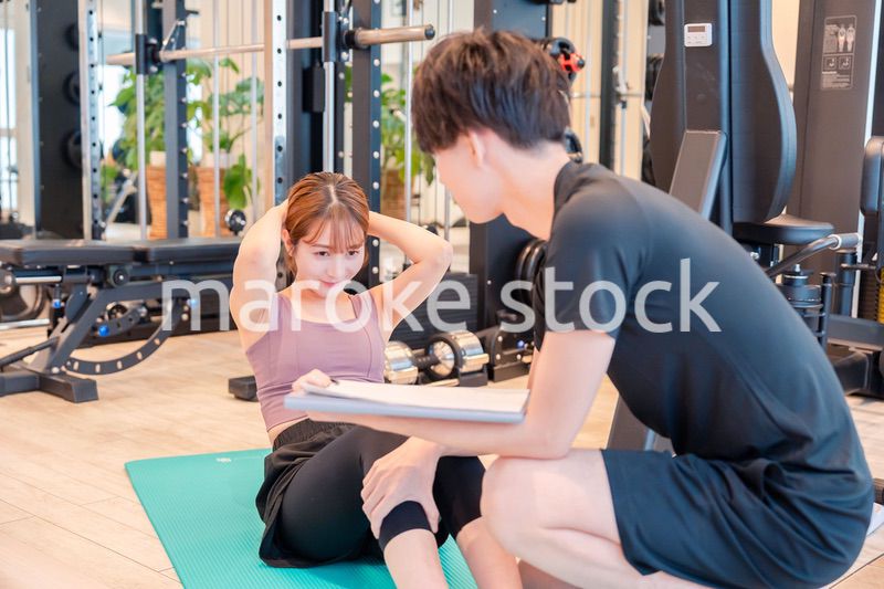 パーソナルジムに通う女性とトレーナー