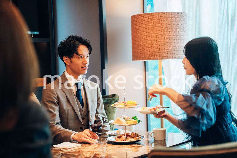 若い女性とアフタヌーンティーを楽しむ男性