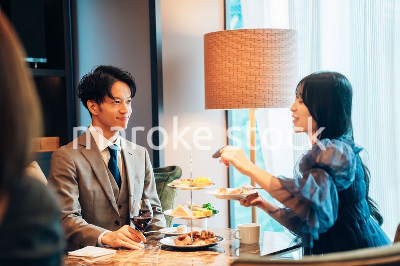 若い女性とアフタヌーンティーを楽しむ男性