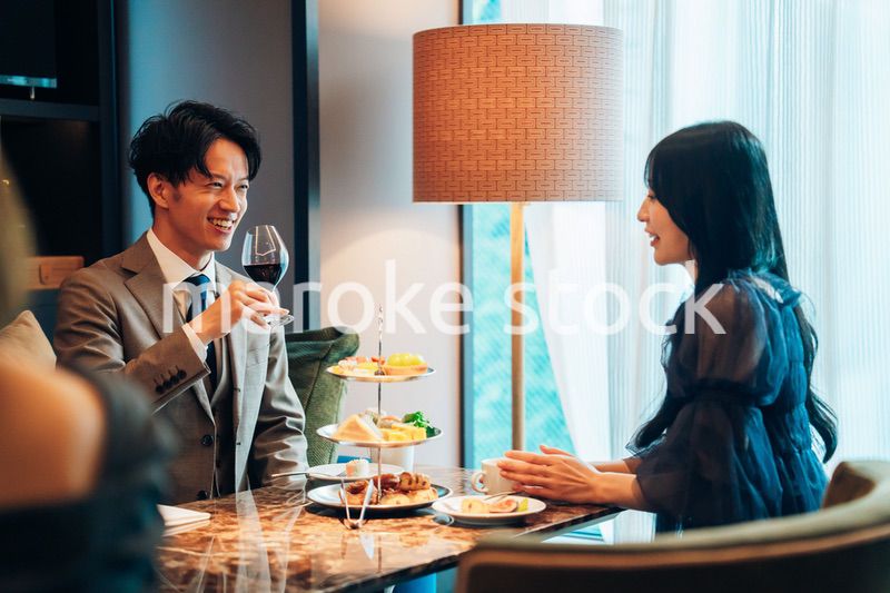 若い女性とアフタヌーンティーを楽しむ男性