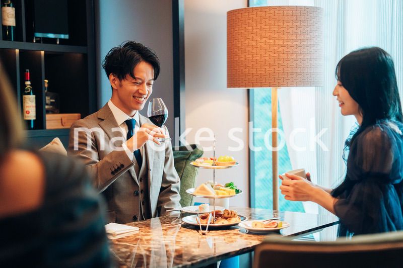 若い女性とアフタヌーンティーを楽しむ男性