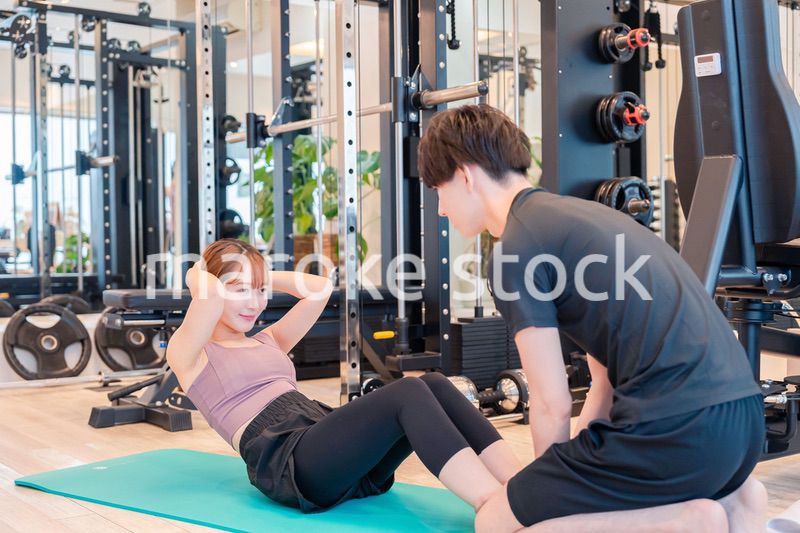 パーソナルジムに通う女性とトレーナー