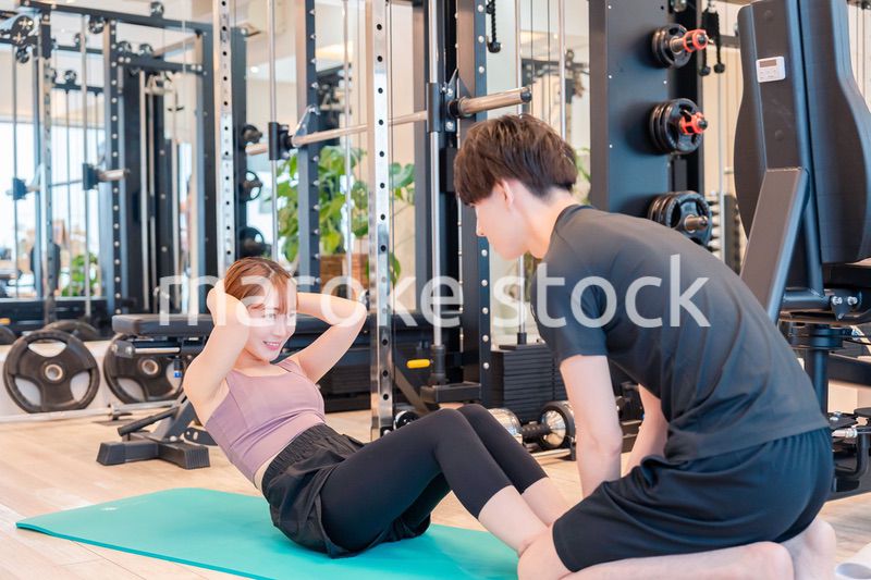 パーソナルジムに通う女性とトレーナー