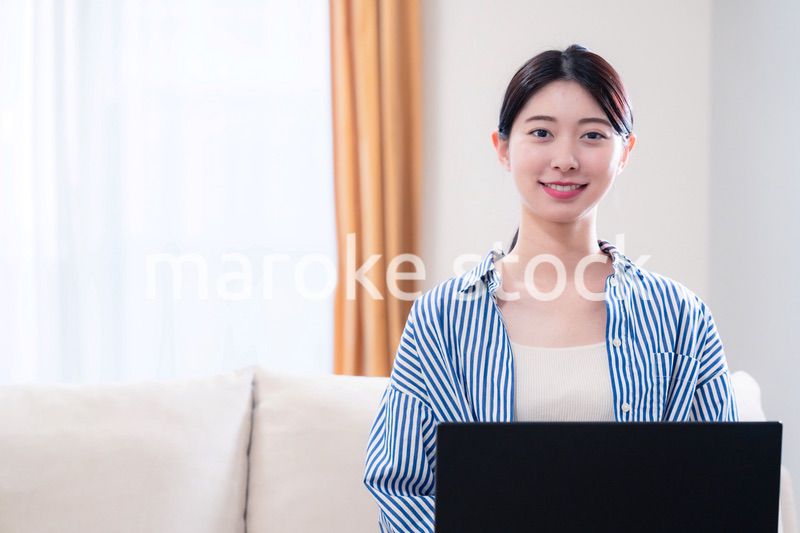 家でリラックスをしてパソコンを使う若い女性