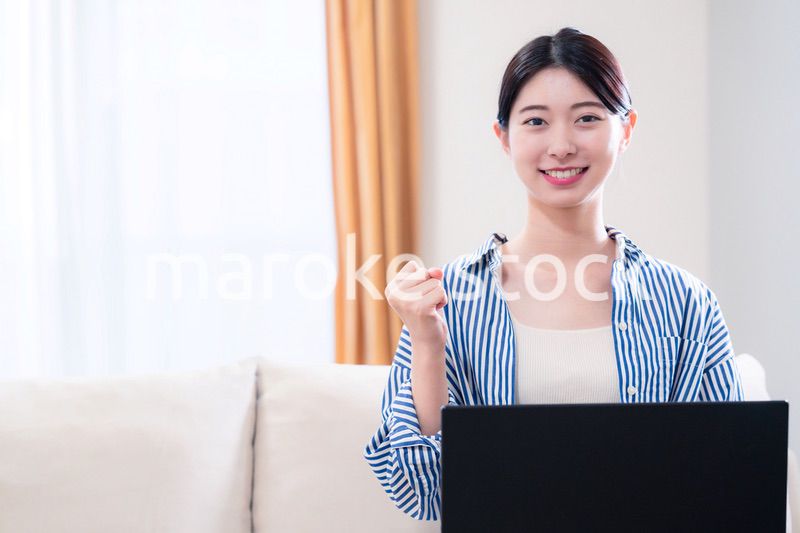 家でリラックスをしてパソコンを使う若い女性