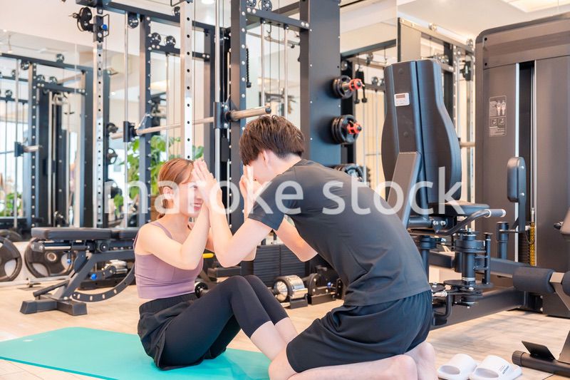 パーソナルジムに通う女性とトレーナー