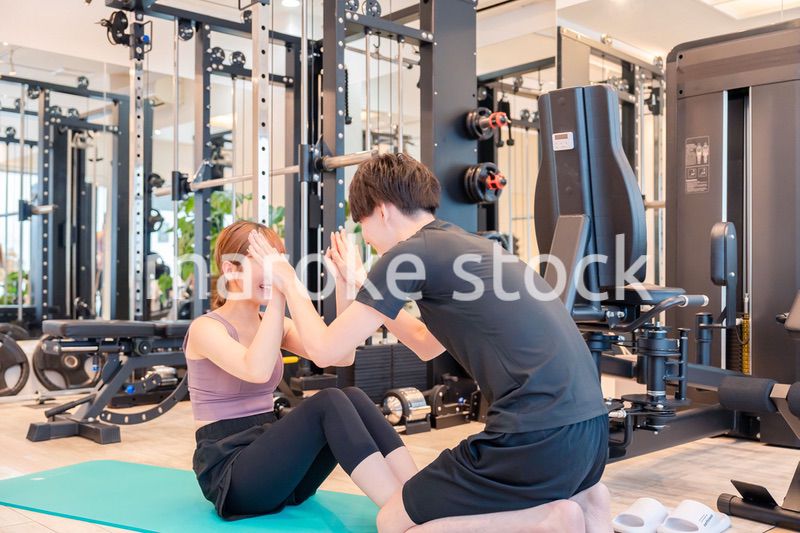 パーソナルジムに通う女性とトレーナー