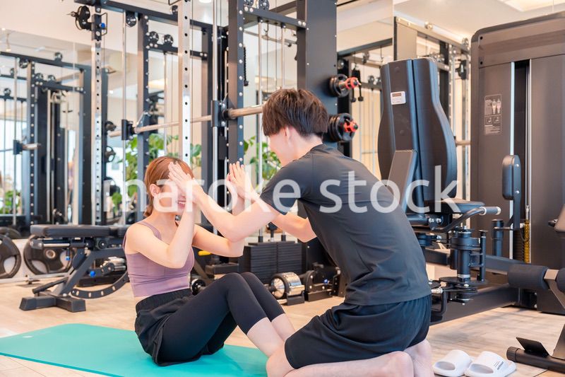 パーソナルジムに通う女性とトレーナー