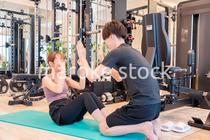 パーソナルジムに通う女性とトレーナー