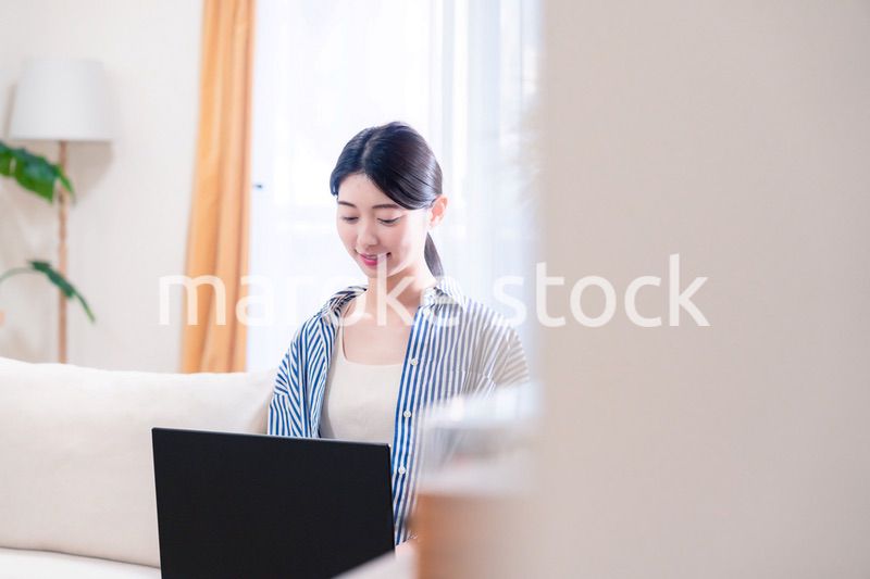 家でリラックスをしてパソコンを使う若い女性
