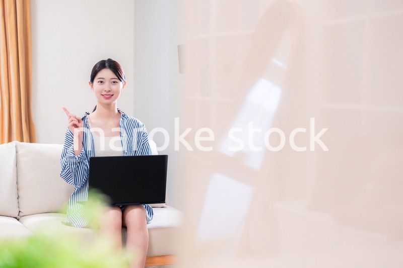 家でリラックスをしてパソコンを使う若い女性