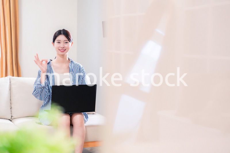 家でリラックスをしてパソコンを使う若い女性