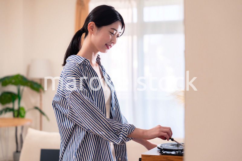 家でレコードを聴く若い女性
