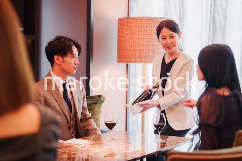 ワインをお客様におすすめをする女性のスタッフ